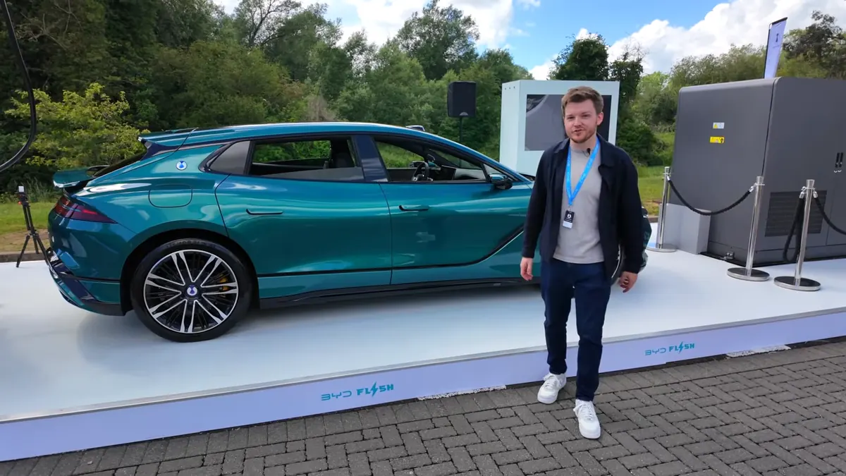 Presenter beside the BYD flash charging setup showing the UK and Europe rollout message