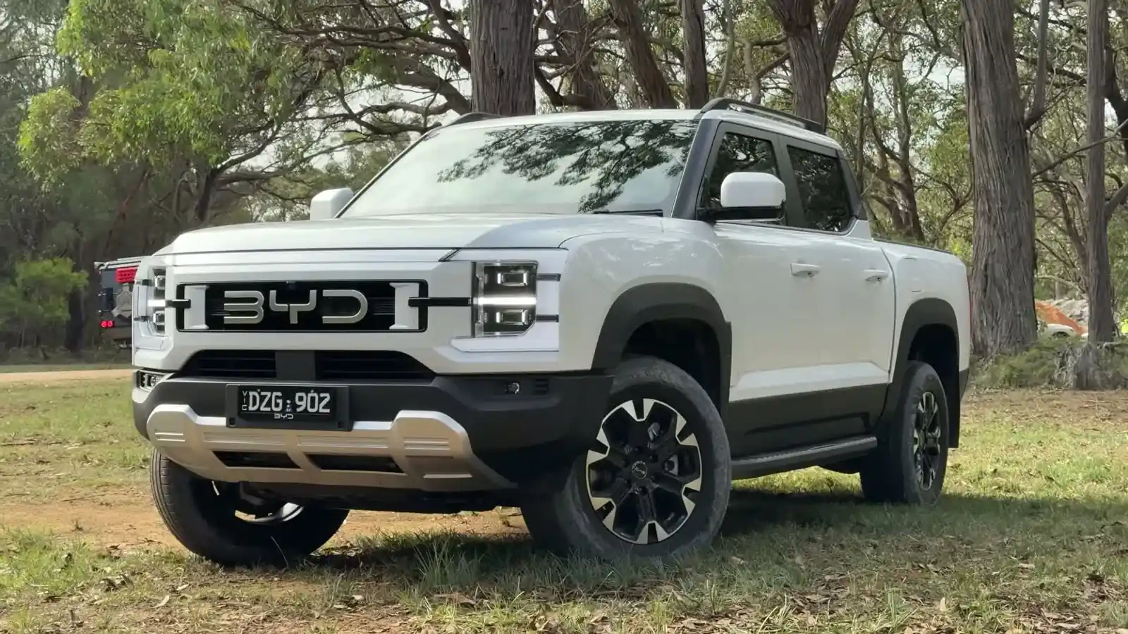 BYD Shark 6 Performance parked off road in a wooded setting