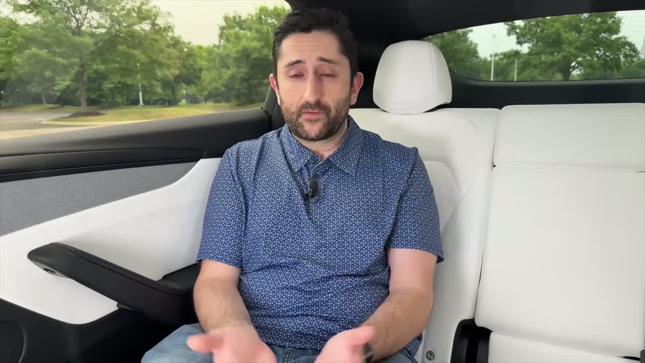 Tesla driver supervising Full Self-Driving on a suburban road