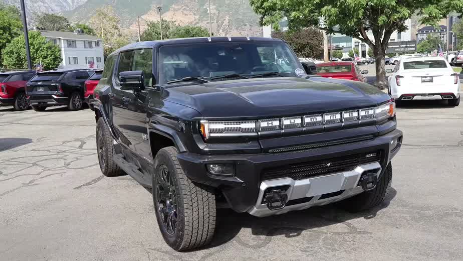 2026 GMC Hummer EV SUV front three-quarter view showing the bold upright stance