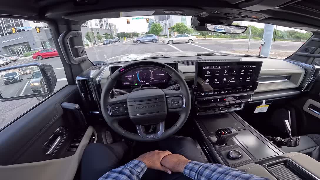 Hummer EV driving shot showing the wide planted stance on all-terrain tires