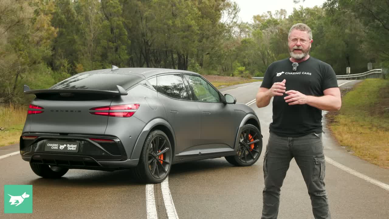 Genesis GV60 Magma parked, showing forged 21-inch wheels and Magma orange calipers