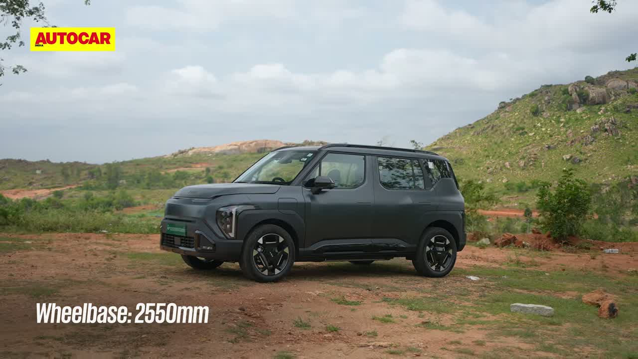 Kia Syros EV front three-quarter view with green EV license plate