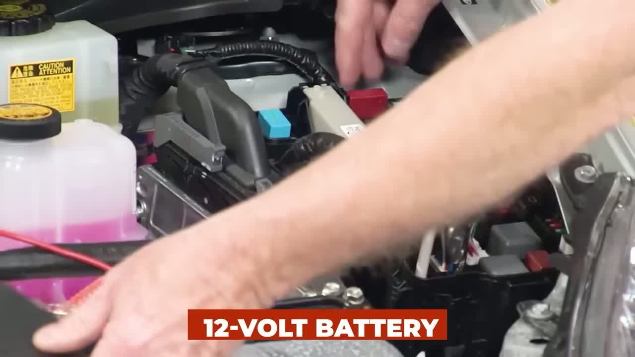 12-volt battery being worked on under the hood of a luxury car