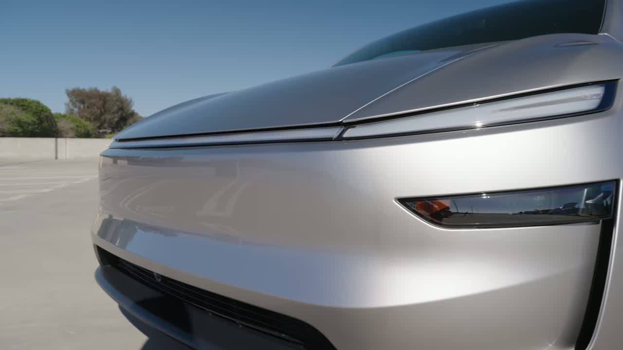 Front-end detail of the Model Y L showing the slim LED light bar and headlight signature