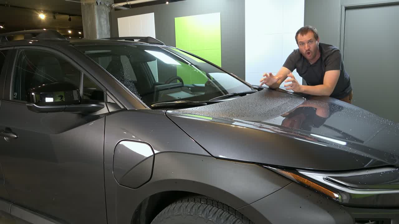 Doug DeMuro at the front of the bZ Woodland, popping the hood to show there is no front trunk and no glove box